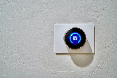 A smart thermostat controls the room temperature. 